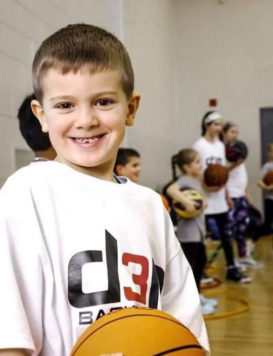 Athlete smiling and holding a basketball at D3P Sports & Community.